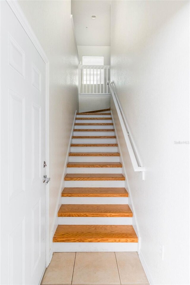 stairway featuring tile patterned flooring