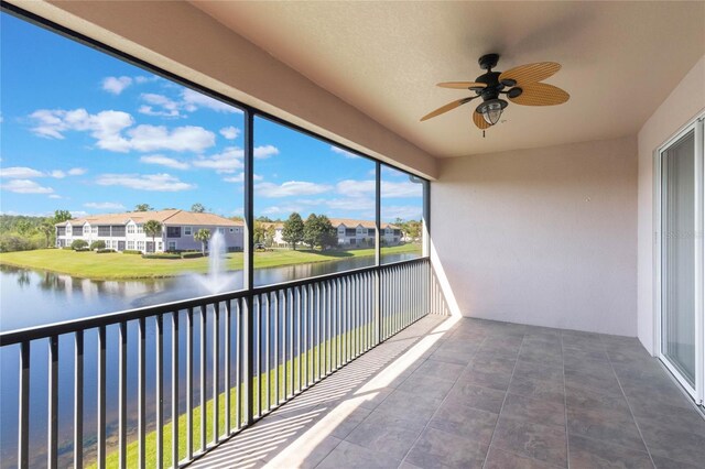 balcony featuring a water view and a ceiling fan