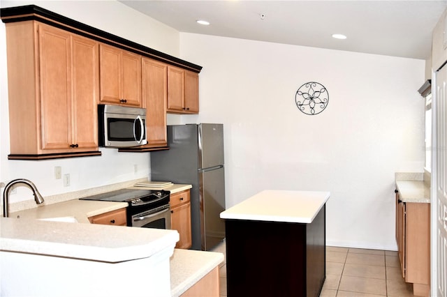 kitchen featuring light tile patterned floors, stainless steel appliances, a peninsula, light countertops, and a center island