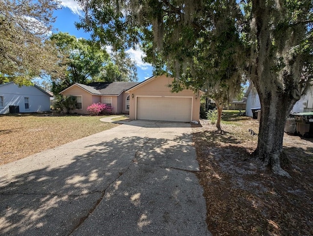 view of front facade featuring a garage, concrete driveway, and stucco siding