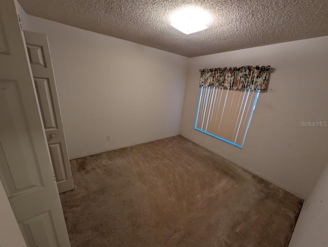 carpeted spare room with a textured ceiling