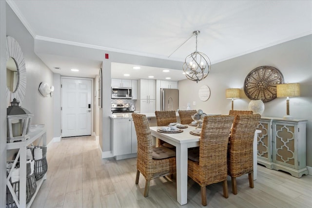 dining area with a notable chandelier, light wood-style flooring, recessed lighting, crown molding, and baseboards