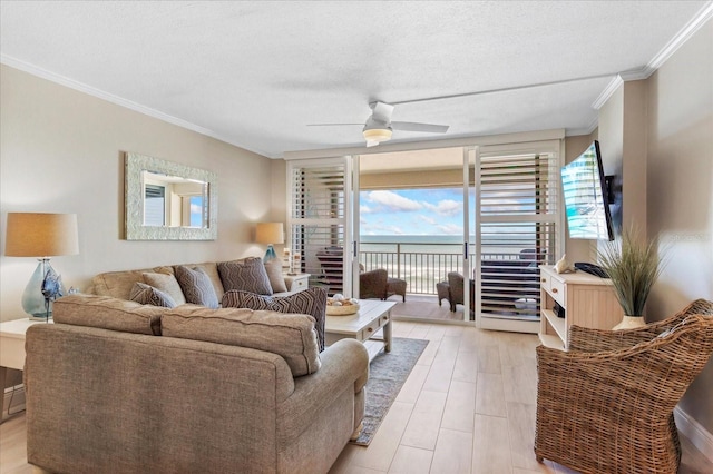 living room featuring ceiling fan, a textured ceiling, light wood-style flooring, and crown molding