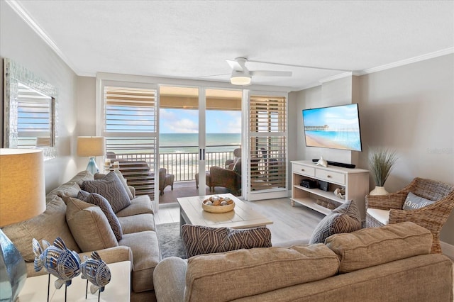 living room with crown molding, a ceiling fan, and light wood finished floors