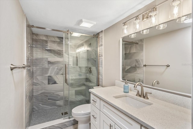 bathroom featuring vanity, toilet, and a shower stall