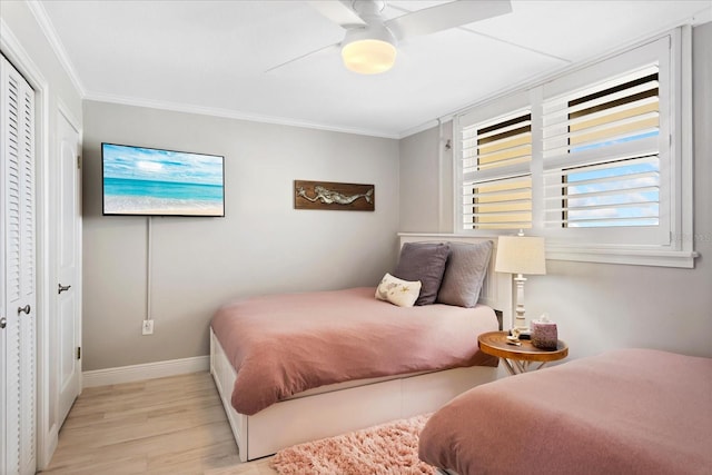 bedroom with light wood finished floors, ceiling fan, crown molding, and baseboards