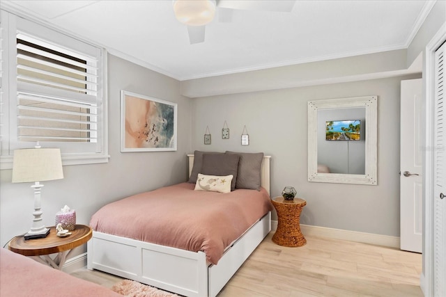 bedroom featuring ceiling fan, wood finished floors, baseboards, and ornamental molding