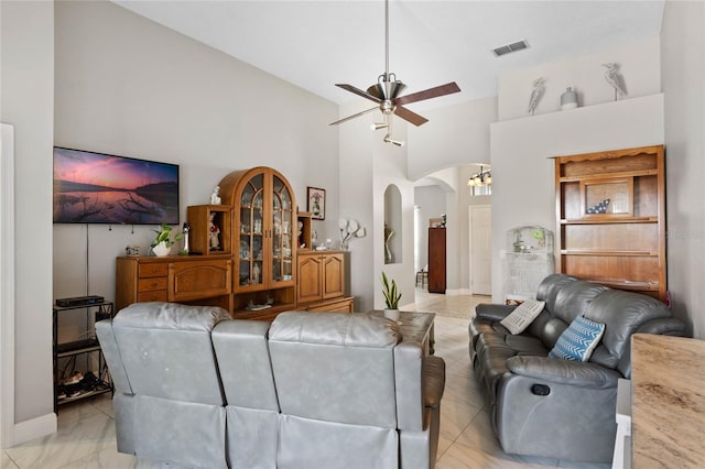 living area featuring marble finish floor, ceiling fan, visible vents, and arched walkways