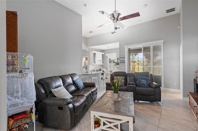 living room featuring ceiling fan, visible vents, and baseboards