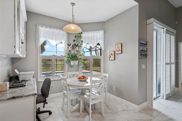 dining room featuring marble finish floor and baseboards