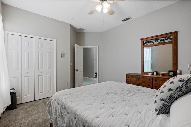 bedroom featuring a ceiling fan, visible vents, a closet, and light colored carpet