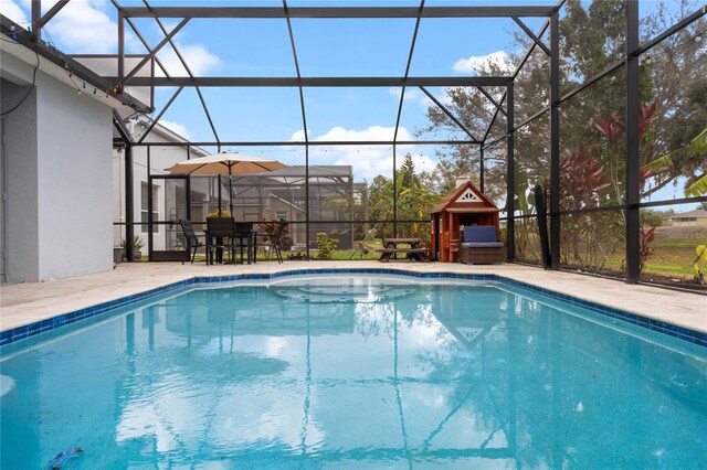 outdoor pool with glass enclosure and a patio