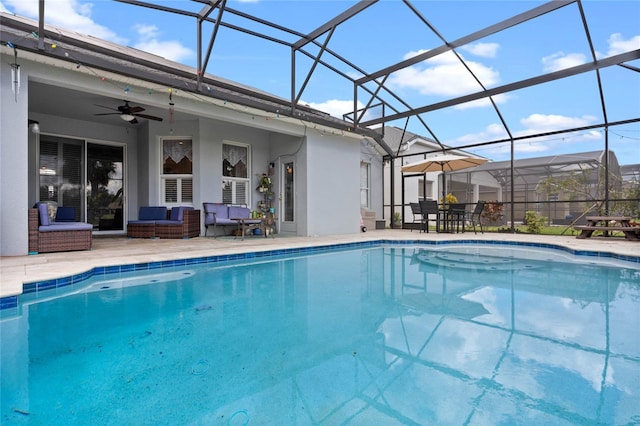 outdoor pool featuring glass enclosure, a patio area, ceiling fan, and an outdoor living space