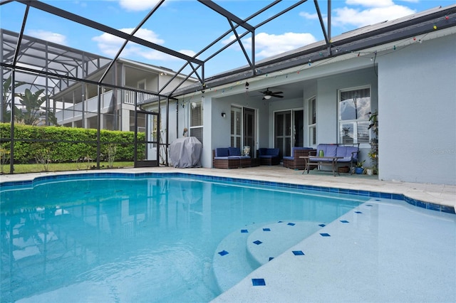 outdoor pool with an outdoor hangout area, a patio, glass enclosure, and a ceiling fan