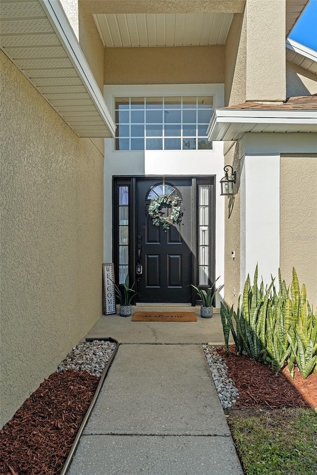 entrance to property with stucco siding