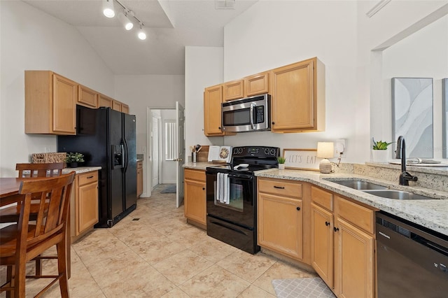 kitchen with a sink, light stone counters, high vaulted ceiling, and black appliances