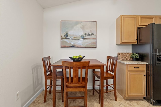 dining area featuring baseboards and lofted ceiling