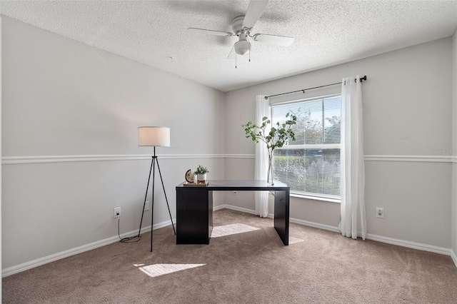 unfurnished office with a textured ceiling, baseboards, carpet, and a ceiling fan