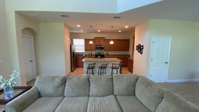 living area featuring arched walkways, visible vents, recessed lighting, and baseboards