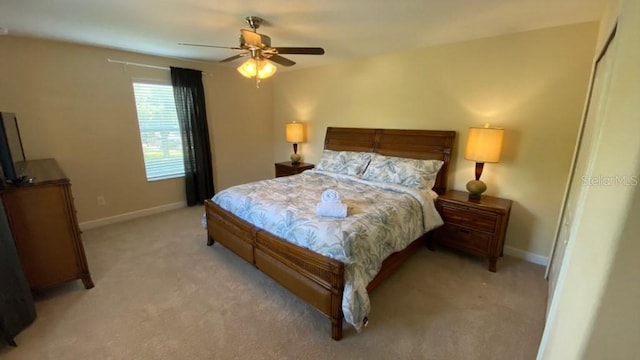 bedroom with light colored carpet, baseboards, and ceiling fan