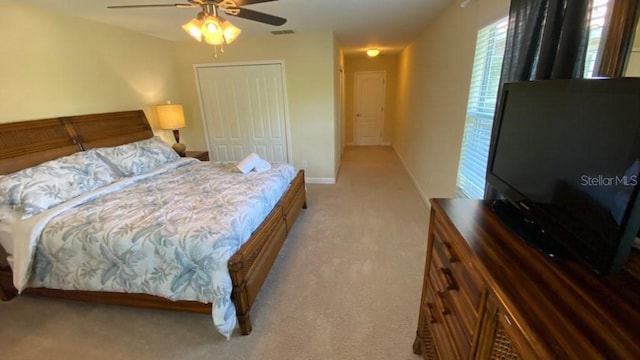 carpeted bedroom with baseboards, visible vents, a closet, and ceiling fan