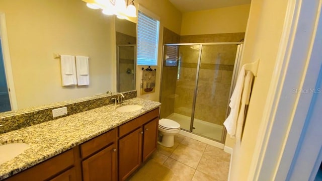 full bathroom featuring tile patterned flooring, toilet, double vanity, a stall shower, and a sink