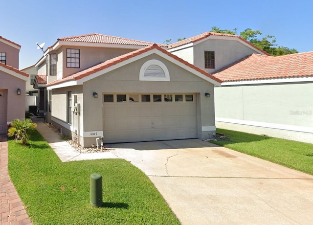 mediterranean / spanish-style house with a tiled roof, stucco siding, driveway, and an attached garage