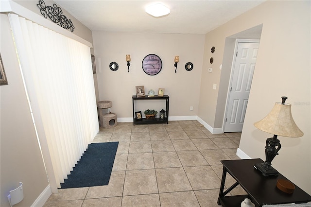 hallway featuring light tile patterned floors and baseboards