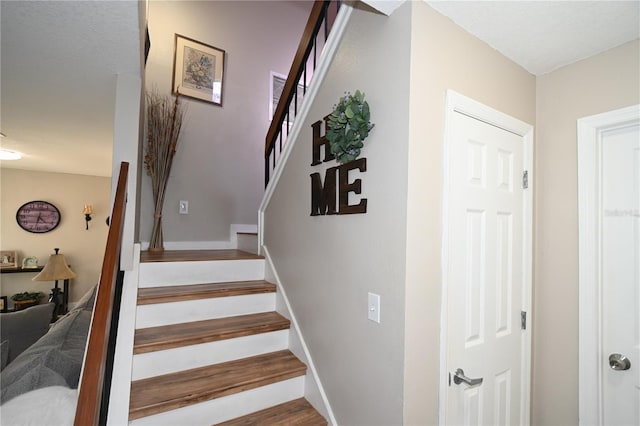 stairway featuring baseboards and wood finished floors