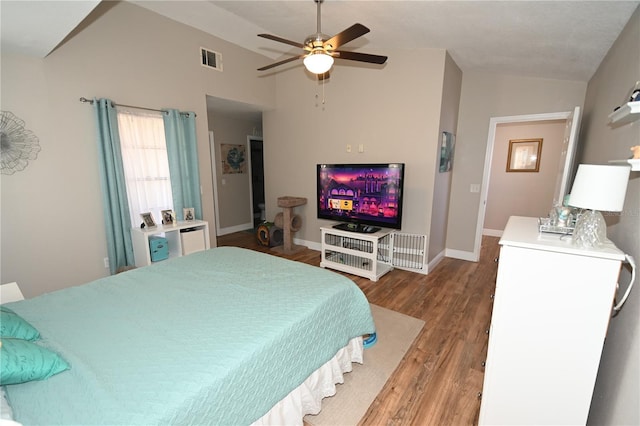 bedroom with visible vents, baseboards, lofted ceiling, and wood finished floors