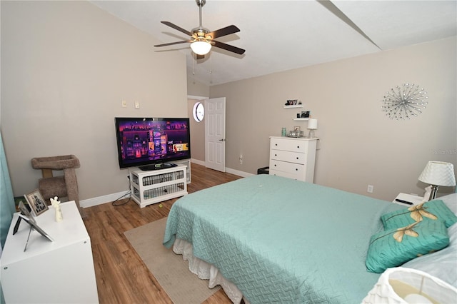 bedroom with baseboards, lofted ceiling, wood finished floors, and a ceiling fan