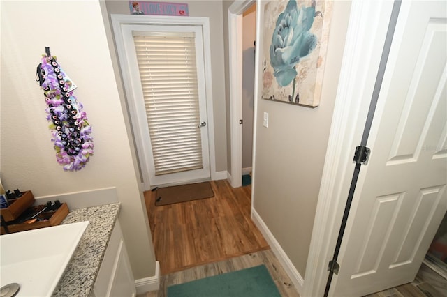 corridor featuring baseboards and light wood-style flooring