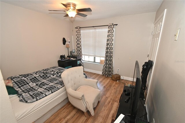 bedroom with ceiling fan, a closet, baseboards, and wood finished floors