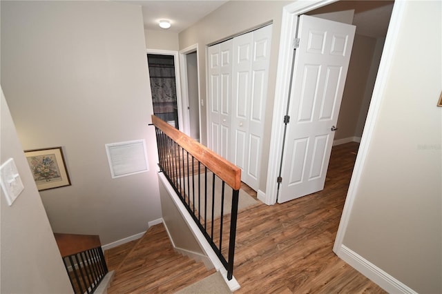 stairs with visible vents, baseboards, and wood finished floors