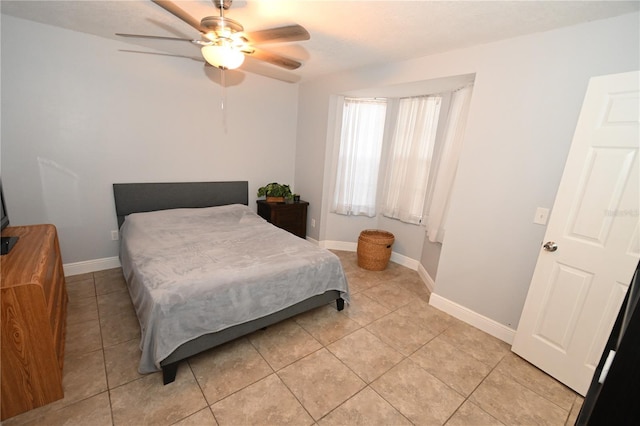 bedroom with light tile patterned floors, baseboards, and a ceiling fan