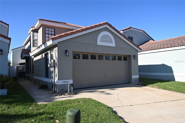 view of front of home featuring stucco siding, an attached garage, driveway, and a tiled roof