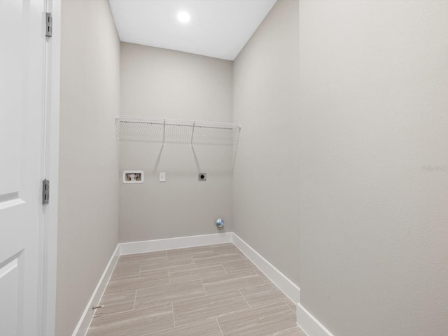 washroom with hookup for a washing machine, laundry area, wood finish floors, baseboards, and electric dryer hookup