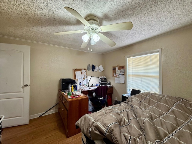 bedroom featuring crown molding, a textured ceiling, wood finished floors, and a textured wall