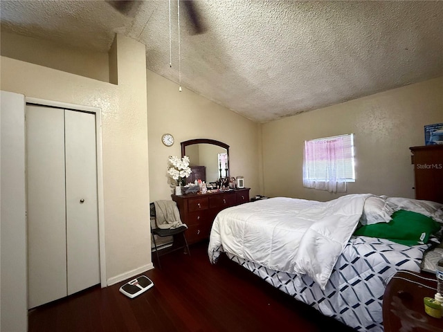 bedroom with a textured ceiling, vaulted ceiling, wood finished floors, and a textured wall