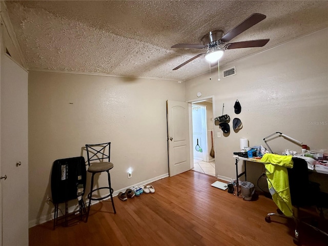 miscellaneous room featuring baseboards, visible vents, ceiling fan, wood finished floors, and a textured ceiling