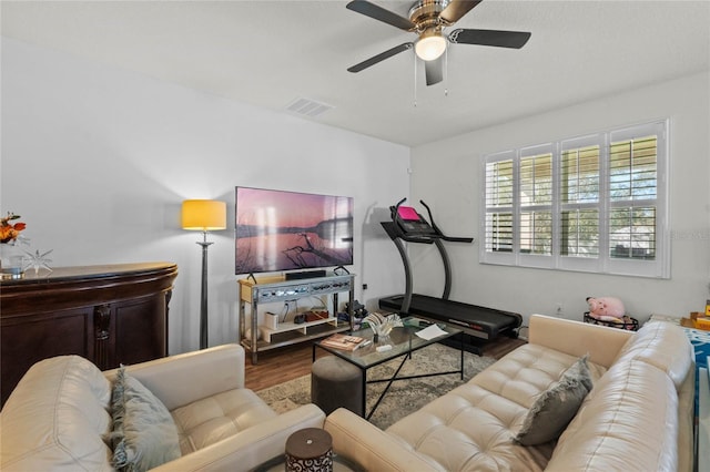 living room with a ceiling fan, wood finished floors, and visible vents