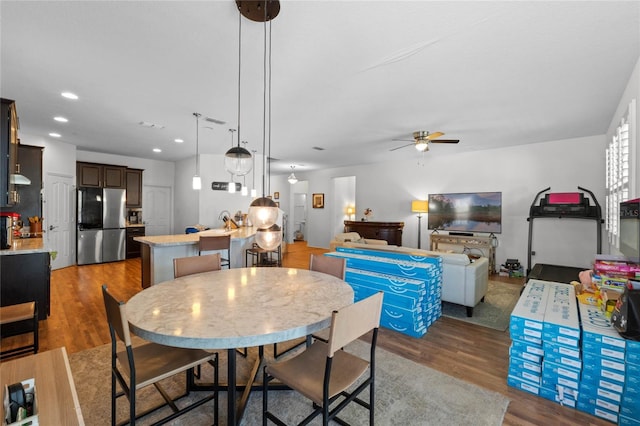 dining room with a ceiling fan, recessed lighting, and wood finished floors