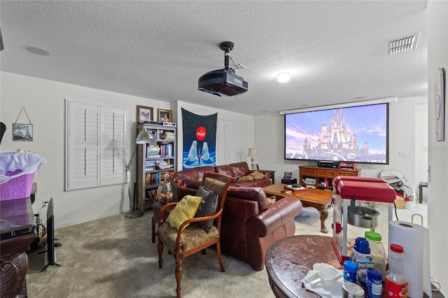 carpeted cinema room with visible vents and a textured ceiling