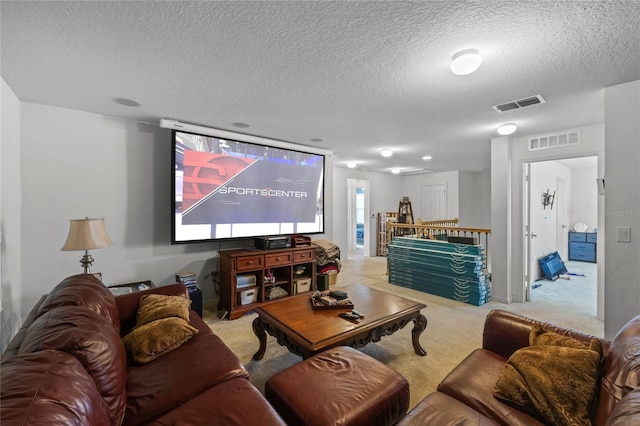 cinema room featuring visible vents, carpet floors, and a textured ceiling