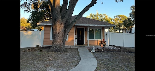 exterior space featuring roof with shingles and fence