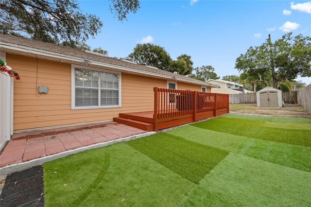 back of property with an outbuilding, a storage unit, a patio area, a fenced backyard, and a wooden deck