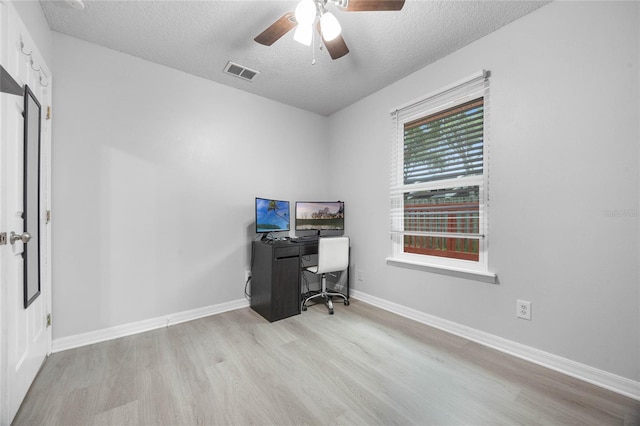 office area with a textured ceiling, ceiling fan, wood finished floors, visible vents, and baseboards