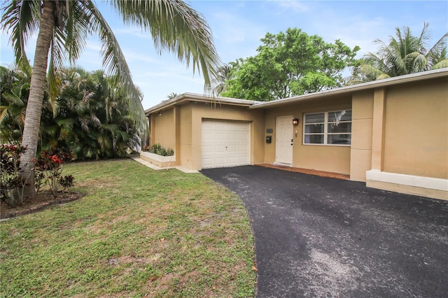 view of front facade with an attached garage, a front yard, aphalt driveway, and stucco siding