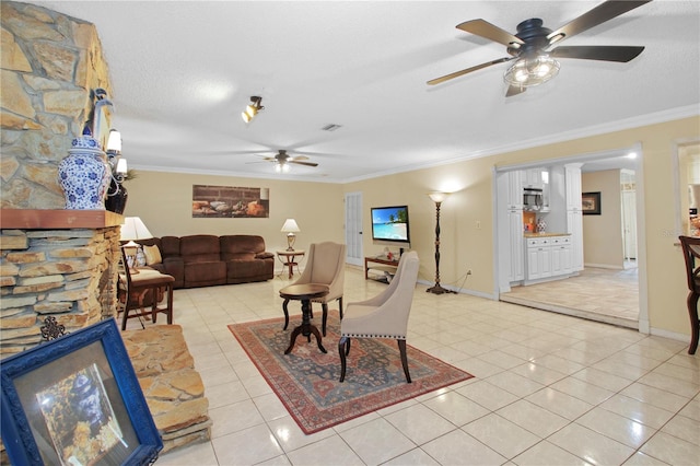 living area with ornamental molding, a textured ceiling, baseboards, and light tile patterned floors