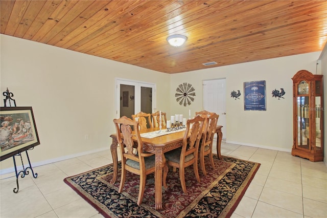 dining space featuring light tile patterned floors, wooden ceiling, and baseboards